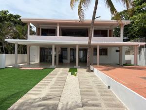 a house with a palm tree in front of it at Front Beach Beautiful house with pool & AC in Pochomil