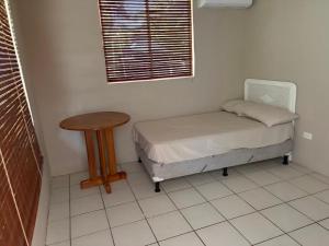 a small bed and a table in a room at Front Beach Beautiful house with pool & AC in Pochomil +13 photos