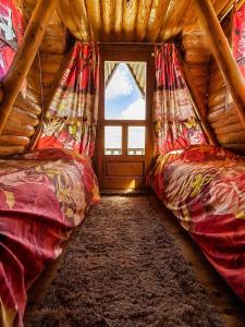 a room with two beds in a log cabin at Komovi Sky House in Andrijevica