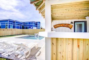 a villa with a swimming pool and a building at 4059 - Bikinis Martinis in Kitty Hawk