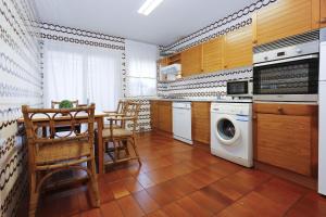 a kitchen with a table and a washing machine at Villa Cococha in Salou