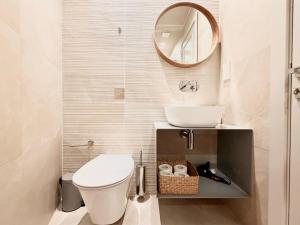 a bathroom with a toilet and a sink and a mirror at Exclusive Retreat off the Sea Front Promenade in Il-Gżira +54 photos