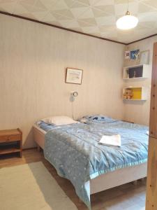 a bedroom with a bed with a blue comforter at Aurora Grande in Saariselka +43 photos