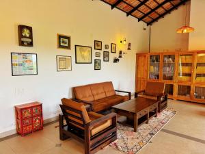a living room with a couch and a table at Leopard Hill Resort - Bandipur in Bandipūr