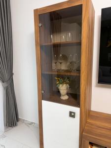 a wooden cabinet with glasses in it at Emerald House 5 in Scheia
