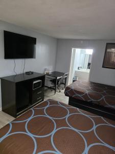 a hotel room with a bed and a flat screen tv at Lamplighter Inn Independence in Independence +18 photos