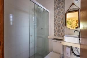 a bathroom with a shower and a sink and a mirror at Vila Tero 400 metros da praia de Boraceia in São Sebastião +41 photos