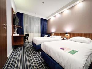 a hotel room with two beds and a desk at ibis Styles Wałbrzych in Wałbrzych +92 photos