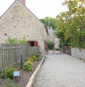 a garden with a wooden fence and a building at Rouges-Gorges 