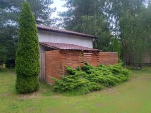 a wooden shed in a yard next to a tree at W Częstochowie in Częstochowa