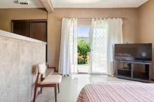 a bedroom with a bed and a sliding glass door at Casa Laderas de Chacras de Coria in Chacras de Coria