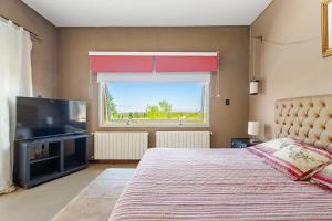 a bedroom with a large bed and a large window at Casa Laderas de Chacras de Coria in Chacras de Coria