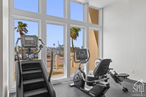 a gym with two exercise bikes in a room with windows at Solare Tower Sunset Panorama Paradise in South Padre Island