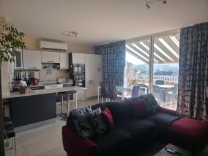 a living room with a couch and a kitchen at Il Bejta penthouse in Qala