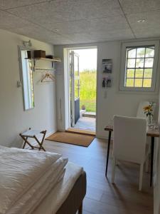 a bedroom with a bed and a table and a dining room at Karensdal B & B in Uldum