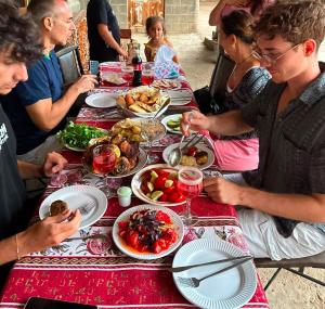 a group of people sitting at a table eating food at AlexMila in Tatʼev