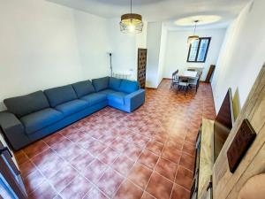 a living room with a blue couch and a table at Casona del Tajuña in Armuña de Tajuña