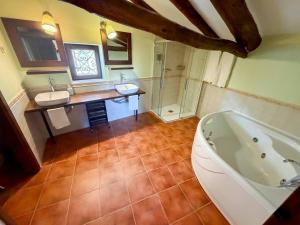 a bathroom with two sinks and a bath tub at Casona del Tajuña in Armuña de Tajuña +42 photos