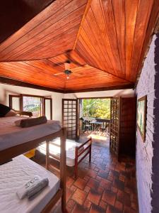 a room with two beds and a wooden ceiling at Numa Boa HOSTEL Búzios in Búzios