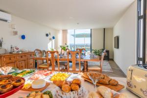 a table with a bunch of bread and pastries on it at Eira das Maçãs - Óbidos 