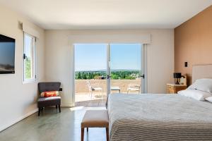 a bedroom with a bed and a view of a balcony at Casa Laderas de Chacras de Coria in Chacras de Coria