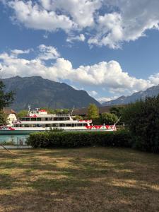 a boat on the water with mountains in the background at Rawda Ferien Wohnung in Interlaken