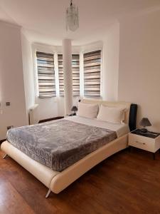 a white bedroom with a large bed with windows at Villa Salo in Labinot i Poshtëm +19 photos