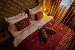a bedroom with a large bed with a headboard and pillows at Hotel Résidence La Falaise in Douala