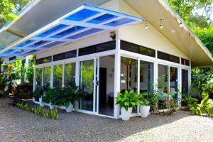 a house with a conservatory with plants at Pino Lodge, Río Celeste in Bijagua