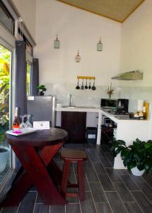 a kitchen with a wooden table and a sink at Pino Lodge, Río Celeste in Bijagua