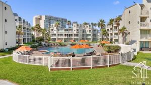 a pool with tables and umbrellas in a resort at Amazing BahiaMar beachfront 2 steps from amenities in South Padre Island