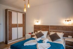 a bedroom with a large bed with blue sheets and pillows at Casa Kollari in Ulcinj
