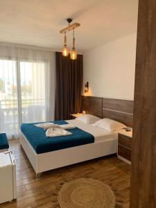 a bedroom with a large bed with a blue blanket at Casa Kollari in Ulcinj