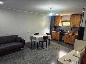 a living room with a table and a couch and a kitchen at Casa nostra in Ambrolauri