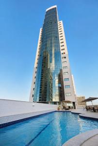 a building with a swimming pool in front of a building at Luxo na Beira Mar - Beach Class Executive 105 in Recife