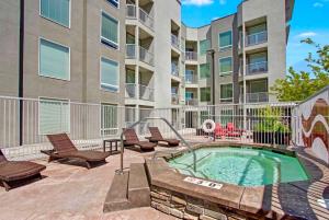 a patio with a hot tub and chairs and a building at Spacious 2-Bedroom Urban Oasis in Salt Lake City