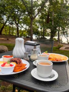 a table with plates of food and cups of coffee at Casa Bambú Hotel in Masaya +68 photos