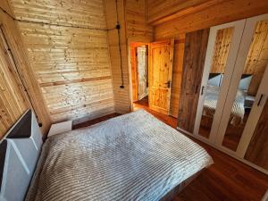 a bedroom with a bed in a wooden cabin at Casa nostra in Ambrolauri