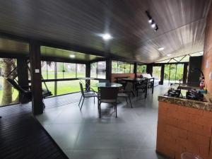 a kitchen and dining area of a house with tables and chairs at Pousada Aquarela de Bombinhas in Bombinhas