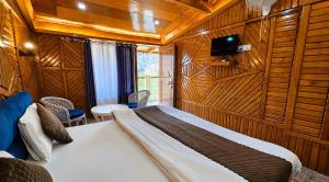 a bedroom with a bed in a room with wooden walls at Naini Hill View Boho in Nainital