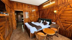 a bedroom with a bed and a table and chairs at Naini Hill View Boho in Nainital