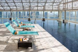 a group of chairs and tables in a pool of water at InterContinental Doha The City by IHG in Doha
