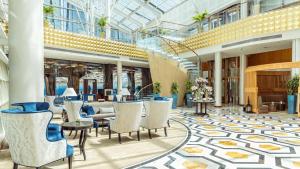 a lobby with chairs and tables in a building at InterContinental Doha The City by IHG in Doha