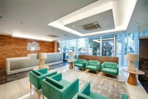 a lobby with green chairs and tables and windows at Holiday Inn Belo Horizonte Savassi by IHG in Belo Horizonte