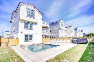 a house with a swimming pool in the backyard at 4059 - Bikinis Martinis in Kitty Hawk +65 photos