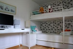 a bedroom with white bunk beds and a tv at Villa near Åhus in Yngsjö