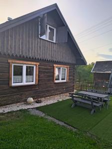 a wooden house with a picnic bench in front of it at Chata Miła Agroturystyka in Dębowiec