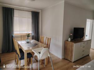 a dining room with a table with chairs and a television at Ferienwohnung Am Wald in Bad Marienberg +18 photos
