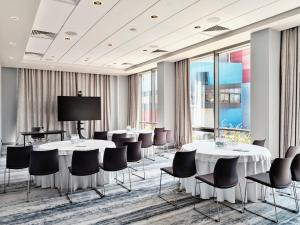 a conference room with tables and chairs and a projection screen at Crowne Plaza Sofia by IHG in Sofia