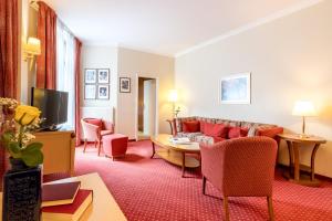 a living room with a couch and a tv at Garner Hotel Berlin - Messe by IHG in Berlin